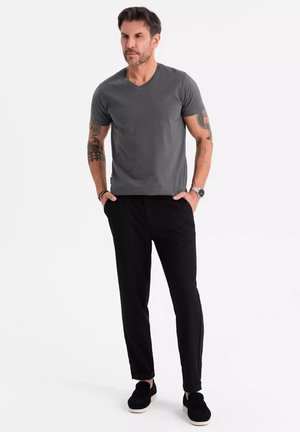 Szary t-shirt z dekoltem w serek, czarne zwężane spodnie i czarne buty wsuwane. Materiał wydaje się gładki; strój jest codzienny i dopasowany.