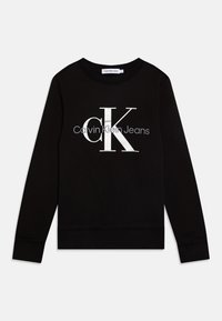 Felpa nera con collo rotondo, maniche lunghe e un grande logo bianco "CK" con il testo "Calvin Klein Jeans" sotto. Tessuto morbido.