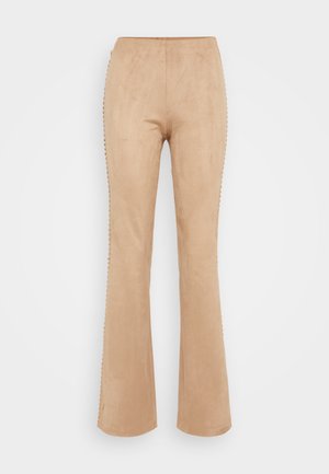 Beige buks med vide ben laget av mykt semsket materiale, med dekorativ søm langs sidene og en jevn tekstur.