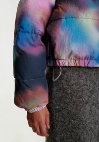 Gevoerde jas met een gradient van roze, blauw en paarse tinten; elastische manchetten en trekkoord details; glanzende, gladde stoftextuur.