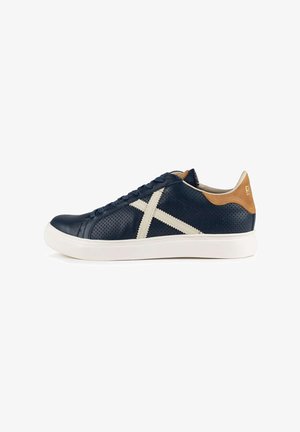 Sneakers in pelle blu navy con dettagli color ocra, design perforato, lacci bianchi e suola in gomma; presentano un distintivo motivo a croce bianca.