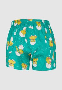 Turquoise patterned boxer shorts featuring cartoon chicks hatching from eggs, elastic waistband, and lightweight cotton material.