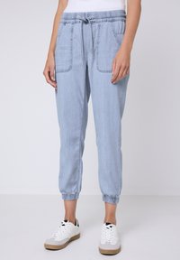 Pantalones jogger de mezclilla en azul claro, con cintura elástica, cierre de cordón, dos bolsillos frontales y puños ajustados.