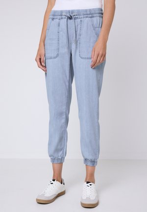Light blue jogger pants made of denim with an elastic waistband, drawstring closure, two front pockets, and tapered cuffs.