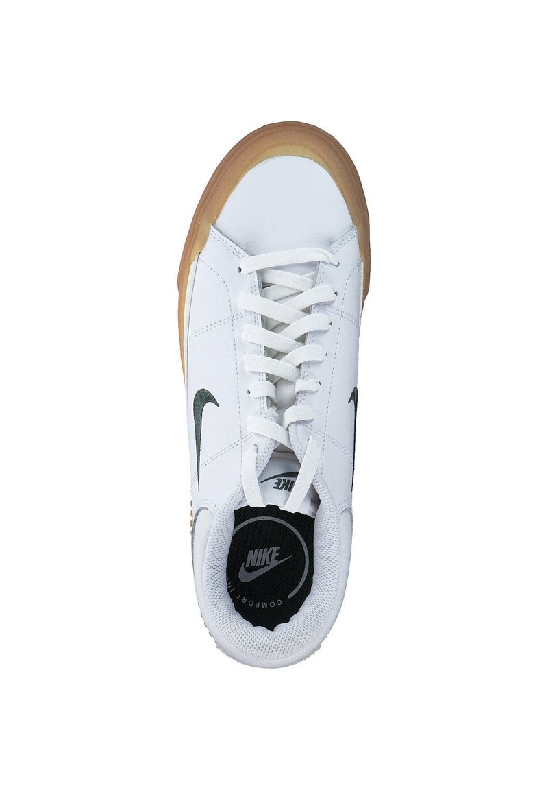 Zapato deportivo blanco con parte superior de cuero liso, logo de Nike en negro, cordones blancos y suela de goma color caramelo. Presenta un collar acolchado y plantilla con logo.