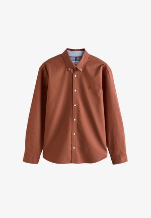 Hnedá košeľa s dlhým rukávom a golierom na gombíky, so snehobielymi gombíkmi a malým logom na hrudi. Vyrobená z ľahkého bavlneného materiálu.