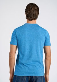 Sininen lyhythihainen t-paita, joka on valmistettu meleeratusta kankaasta. Paidassa on pyöreä pääntie ja rento istuvuus, sileä pinta ja minimalistinen muotoilu.