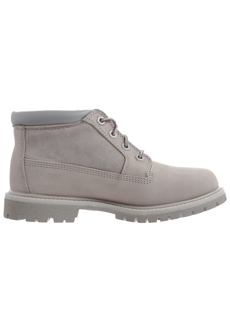 Bottines chevilles gris clair en daim avec un col en cuir lisse, dotées de lacets ronds, d'une semelle résistante et de détails de couture décontractés.
