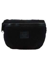 Czarny woreczek z polaru o chropowatej powierzchni, zamykany na zamek błyskawiczny, z małą prostokątną naszywką z logo na froncie. Okrągły kształt z miękkimi krawędziami.