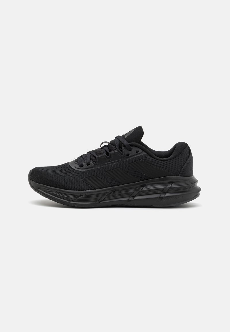 Chaussure de sport noire avec une tige en mesh texturé, une semelle en caoutchouc solide, un intercalaire rembourré et un laçage à l'avant avec des œillets renforcés.