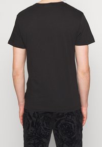 Svart kortärmad T-shirt med rund halsringning. Slät textur, enkelt design, inga synliga logotyper eller mönster. Lämplig för vardagsbruk.