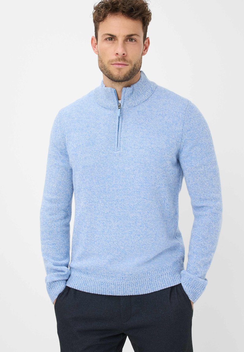 Hellblauer Strickpullover mit Reißverschlusskragen, gerippten Bündchen und Saum. Die Textur ist weich und leicht meliert für zusätzliche Tiefe.