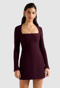 Bordeaux-kleurige, aansluitende jurk met een vierkante halslijn en lange mouwen, gemaakt van een gladde stof. Voorzien van op maat gemaakte naden en een mini-lengte.