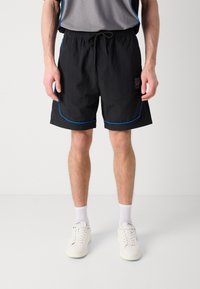 Pantalones cortos negros con ribete azul, cintura con cordón y detalle de logo. Tejido ligero y corte relajado, adecuados para uso casual.