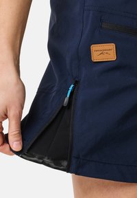 Marineblauwe rok met een zijrits, voorzien van een contrasterende blauwe trekband en een zwarte mesh voering. Inclusief een tan merkpatch.
