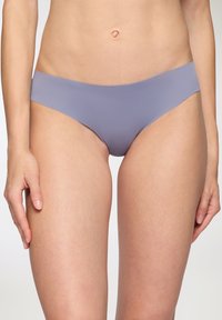 Slip bikini color lilla chiaro con una texture liscia e copertura minima, caratterizzato da una vita senza cuciture per il massimo comfort e un design pulito.