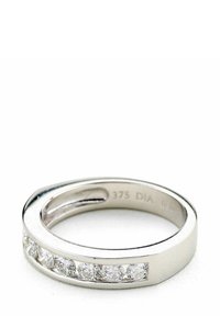 Balto aukso žiedas su plokščiu juosteliu, kuriame yra septynios skaidrios apvalios deimantų, įstatytų horizontaliai kanale. Lygi, poliruota apdaila.