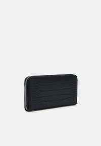 Black zip-around wallet made of textured faux crocodile leather. Features a smooth zipper and a rectangular shape.