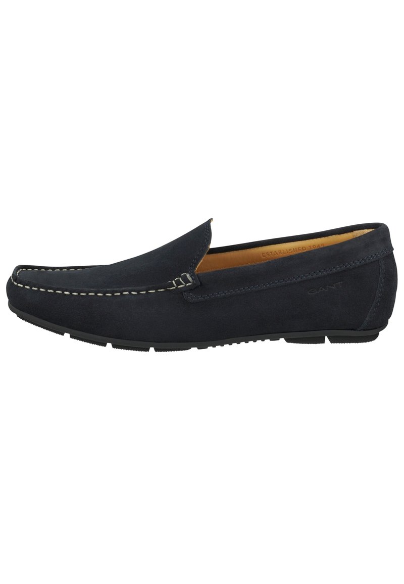 Marineblaue Wildleder-Slipper mit kontrastierenden weißen Nähten, flacher Gummisohle, seitlichem Schlupfdesign und geprägtem Logo an der Seite.
