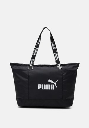 Czarna torba typu tote marki Puma z białym logo Puma i oznakowanymi rączkami na jednolitym białym tle.