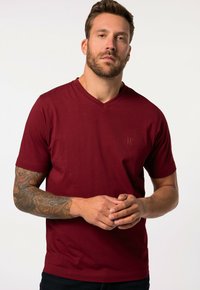 Camiseta de algodón burdeos con cuello en V, con mangas cortas y un sutil logo de JP en el pecho. Textura suave y diseño ajustado.