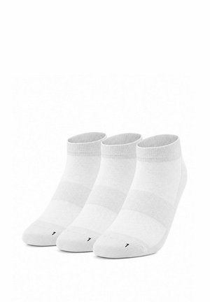 Tre paia di calzini bianchi alla caviglia con suole imbottite e un numero di taglia "7" stampato vicino alle dita, disposti uno accanto all'altro.