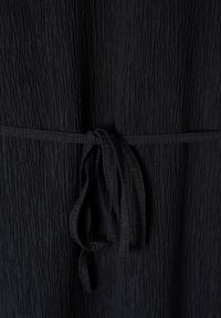 Crna haljina od teksturiranog materijala s naboranim dizajnom i vezanim remenom u struku, koja ima mekanu, lepršavu teksturu.