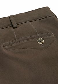 Brune bomuldsbukser med en tekstureret finish, der har en baglomme prydet med en guldknap og diskrete sømdetaljer.