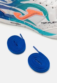Scarpa da ginnastica bianca con accenti colorati blu e arancione. Include due lacci blu arrotolati con estremità in plastica. Il design presenta dettagli perforati.