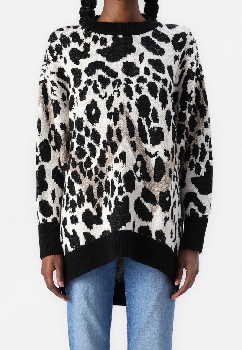 Knit svetr v černé, bílé a béžové leopardí potisky s ribovanými černými detaily. Má volný střih a kleslé ramena.