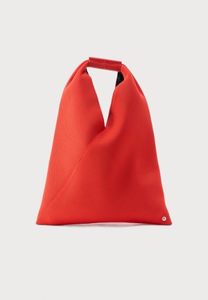 Geantă din material textil roșu, triunghiulară, cu mâner superior pliat și detaliu mic cu nasture argintiu pe fundal simplu.