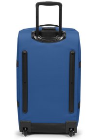 Valigia blu con design rigido, accenti in plastica nera, manico estensibile e quattro ruote per la mobilità. Texture liscia e caratteristiche minime.