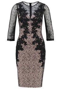 Svart spetsklänning med genomskinliga trekvartsärmar, blommönster ovanpå en naken bas, figurnära passform och dragkedja bak.