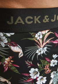 Schwarzer Bund mit "JACK & JONES" in Gold. Florales Muster in verschiedenen Schattierungen von Rosa, Grün und Weiß auf schwarzem Hintergrund. Glatte Textur.