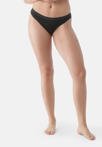 Bikini in cotone nero con una ampia cintura elastica, design a vita bassa e copertura minima, caratterizzato da cuciture lisce e una texture morbida.