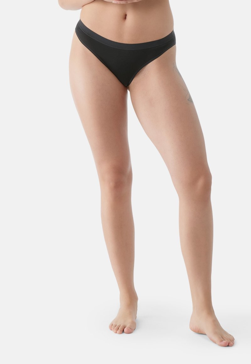 Bikini in cotone nero con una ampia cintura elastica, design a vita bassa e copertura minima, caratterizzato da cuciture lisce e una texture morbida.