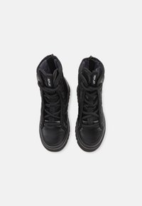 Sorte højtop sneakers med en tekstureret læderoverdel, tykk gummisål og fremtrædende snøresystem. Har en logo-tag på tungen.