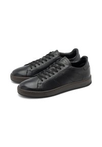 Adidași din piele neagră cu un finisaj neted, vârf rotund și șase gauri pentru șireturi. Talpa este de culoare maro închis, cu o textură subtilă și logo-ul mărcii.