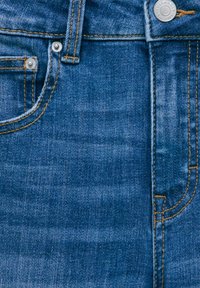 Jean en denim de couleur bleu foncé avec un léger effet délavé, design décontracté, coutures en cuivre, bouton en métal et détail de poche avant.