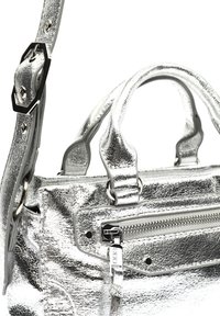 Silverfärgad metallisk handväska med texturerad yta, dubbla handtag, avtagbar axelrem och blixtlåsförsedd framlomma med metalliska detaljer.