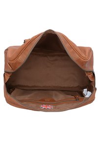 Braune Leder-Duffel-Tasche mit geräumigem Innenraum, Reißverschluss und kleiner Innentasche. Gefüttert mit braunem Stoff, mit einem Tag in Form der UK-Flagge.