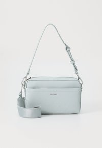 Borsa a tracolla di colore azzurro chiaro realizzata in materiale sintetico testurizzato. Caratterizzata da una chiusura con zip, una tracolla regolabile e un logo discreto sul davanti.