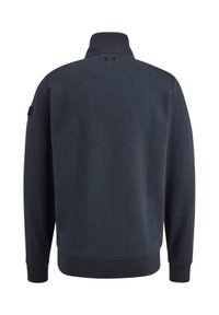 Veste bleu marine avec motif géométrique matelassé sur le panneau arrière, col montant et longues manches avec poignets et ourlet côtelés.