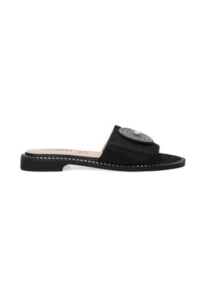 Schwarze Wildleder-Slidesandalen mit offenem Zehenbereich und einer kreisförmigen silbernen Verzierung. Mit einer flachen Sohle und kontrastierenden Nähakzenten.