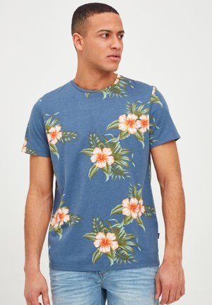 Blaues Baumwoll-T-Shirt mit Rundhalsausschnitt, das ein florales Muster mit orangefarbenen und weißen Blumen sowie grünen Blättern auf der Vorderseite zeigt.