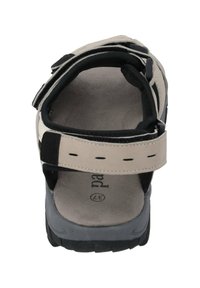 Beige sandal med svarta detaljer, justerbar rem och strukturerad grå sula. Öppen design bak med vadderat fotinlägg för komfort.