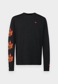 Schwarzes Langarmshirt mit lebendigen orangenen Flammendesigns an den Ärmeln und einem kleinen roten Logo auf der Brust. Aus weichem Baumwollmaterial.
