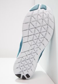 Tyrkysová sportovní bota s texturovaným svrškem a bílou gumovou podrážkou s geometrickým vzorem pro lepší přilnavost.