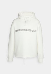 Vit huva sweatshirt i bomull. Har en framficka i känguru-stil och dragsnoddar. "EMPORIO ARMANI"-logotyp i svart över bröstet.