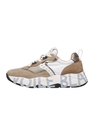 Beiger und weißer Sneaker aus Mesh- und Veloursmaterialien, mit weißen Schnürsenkeln und dicker Sohle, die von großem hellgrauem Text umwickelt ist.